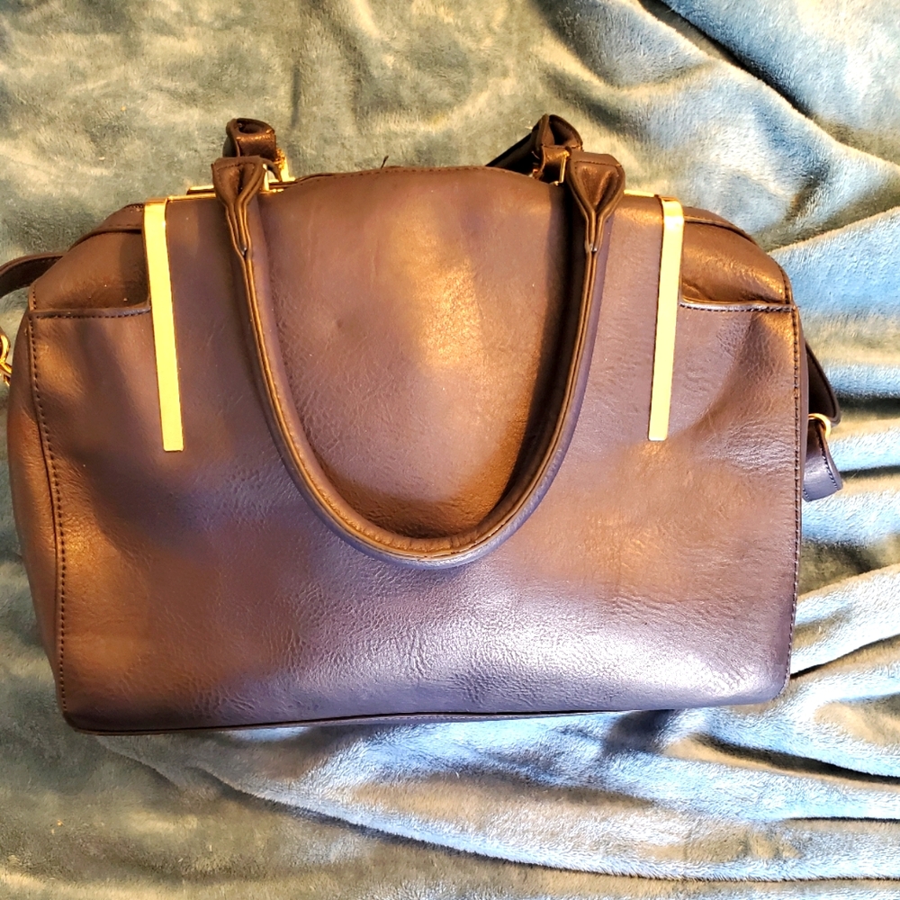 Navy blue multi pocket hand bag with detachable strap.